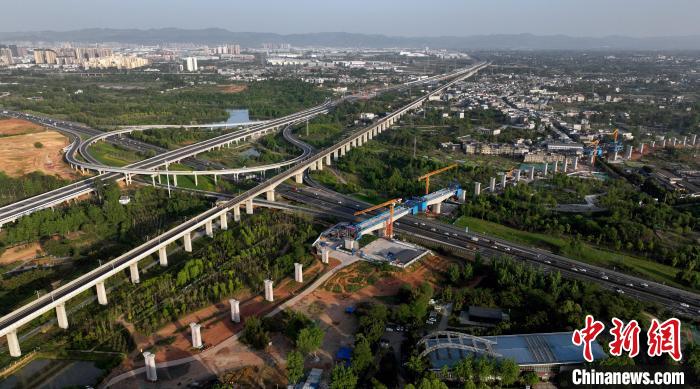 航拍正在建設(shè)的跨越成都繞城高速公路連續(xù)梁施工現(xiàn)場，旁邊依次為已運營的成渝高速鐵路和機(jī)場高速公路?！⒅铱?攝