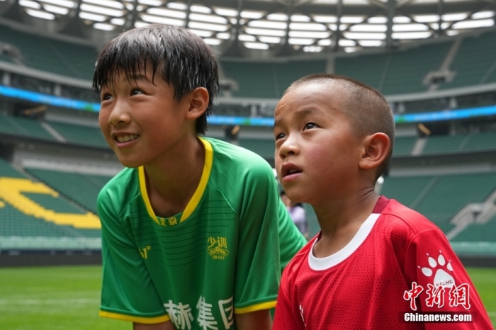 圖為北京國安小球員陳小北和7歲的俄金仁增在一起觀看場內(nèi)播放的紀(jì)錄片。<a target='_blank' href='/' _fcksavedurl='/'><p  align=