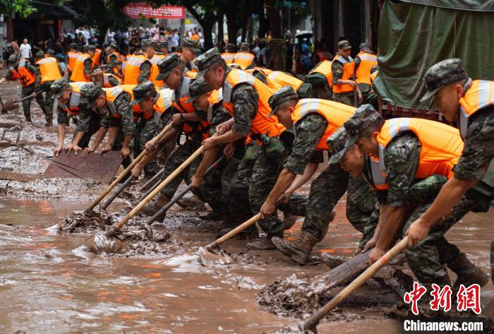 7月4日，萬州區(qū)五橋街道，武警官兵清理街道上的淤泥。　冉孟軍 攝