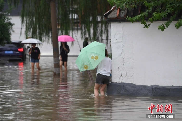 7月31日，市民行走在雨中的北京房山區(qū)瓦窯頭村。北京市氣象臺當(dāng)日10時發(fā)布分區(qū)域暴雨紅色預(yù)警信號。北京市水文總站發(fā)布洪水紅色預(yù)警，預(yù)計當(dāng)日12時至14時，房山區(qū)大石河流域?qū)⒊霈F(xiàn)紅色預(yù)警標(biāo)準(zhǔn)洪水。<a target='_blank' href='/'><p  align=