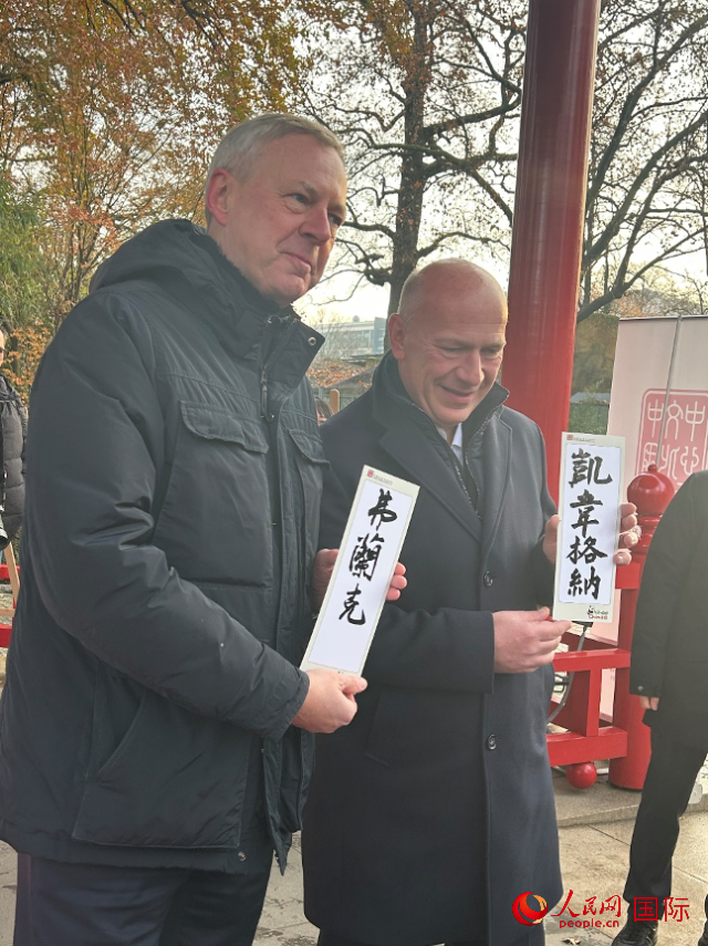 柏林市長韋格納（右）、動(dòng)物園監(jiān)事會(huì)主席布魯克曼（左）手持中國文化中心工作人員現(xiàn)場手書的中文名字。人民網(wǎng)記者 徐馨攝