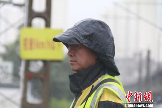 蘭州西工務(wù)段蘭州線路車間防護(hù)員雨中巡查?！⊥豕廨x 攝