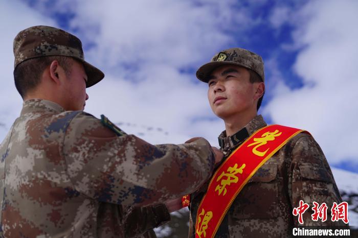 排長(zhǎng)王朝偉(圖左)給退伍老兵佩戴大紅花。　西藏山南軍分區(qū)某團(tuán)供圖