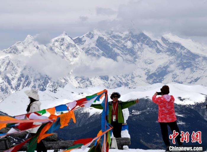 圖為5月14日，西藏林芝色季拉山觀景臺(tái)，游客與南迦巴瓦峰合影。　李林 攝