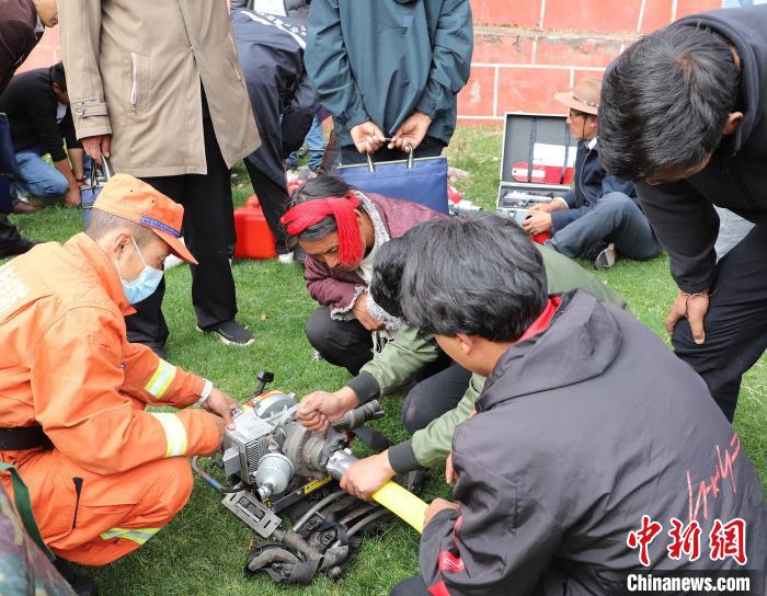 圖為森林消防員為護(hù)林員講解滅火裝備的使用方法。　昌都市森林消防支隊(duì) 供圖