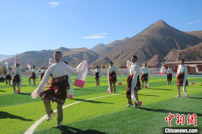 圖為青海師范大學(xué)附屬玉樹實(shí)驗(yàn)學(xué)校學(xué)生在綠茵場(chǎng)跳起囊謙古舞—卓根瑪?！〕逃?攝