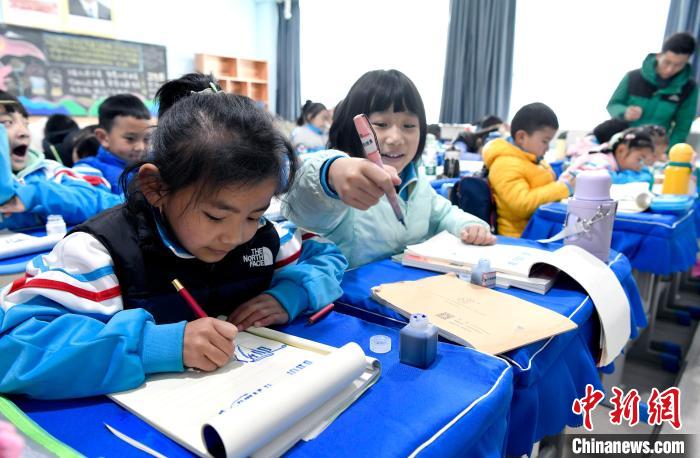 3月14日，西藏拉薩市第一小學(xué)一年級六班學(xué)生白瑪朗珍(圖左)在藏語文課上書寫藏文。　李林 攝