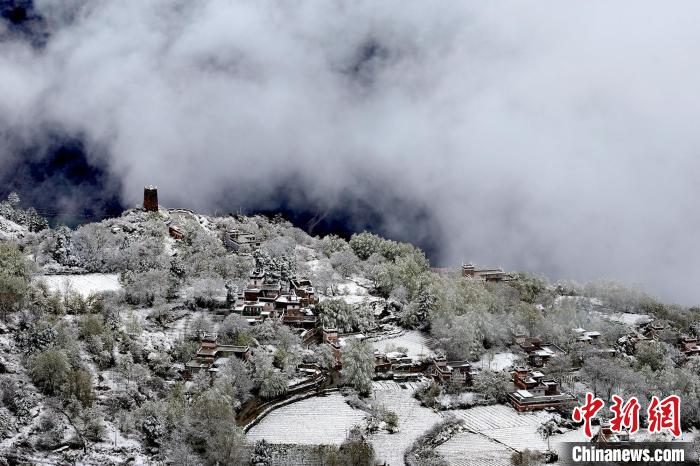 雪后的藏寨和碉樓構(gòu)成美麗的雪景?！〗党鯘衫?攝