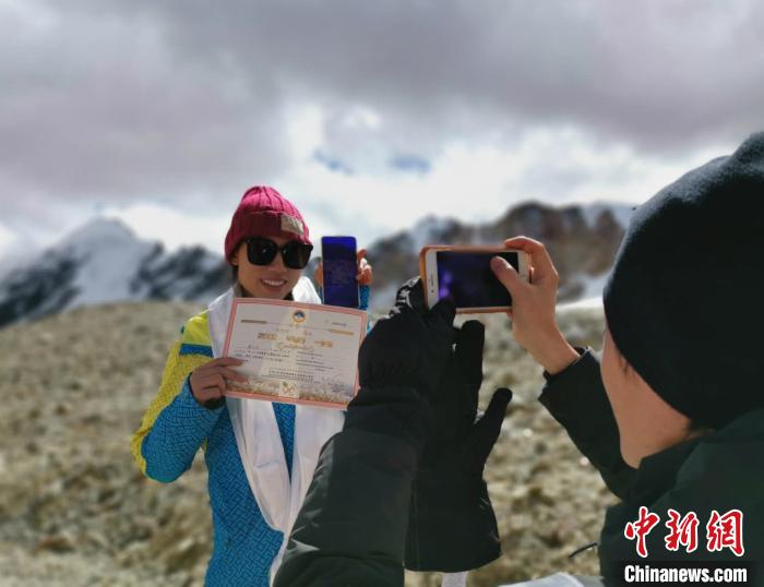 圖為5日，登頂洛堆峰的登山者獲得西藏自治區(qū)登山協(xié)會頒發(fā)的登頂證明?！垈?攝