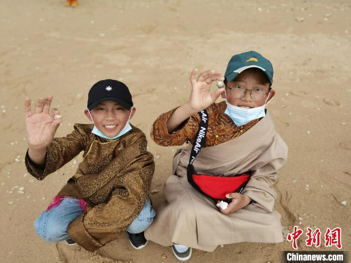 圖為西藏青少年在海邊拾貝殼。西藏航空 供圖