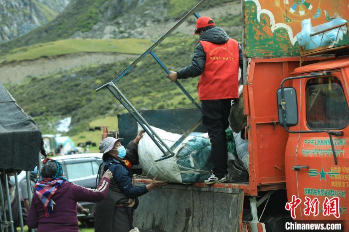 圖為工作人員幫助牧民們卸家具?！÷蹇?攝