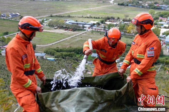 技能大練兵過程中，消防員在陡坡上向蓄水池注水?！±顕鵂c 攝