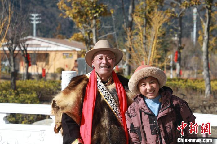 圖為林芝市巴宜區(qū)布久鄉(xiāng)仲果村村民桑杰與孫子一起參加藏歷新年活動?！埩?攝