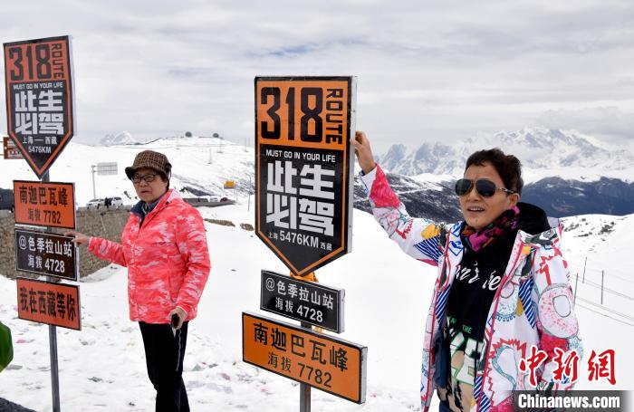 圖為5月14日，西藏林芝色季拉山觀(guān)景臺(tái)，游客與南迦巴瓦峰合影?！±盍?攝